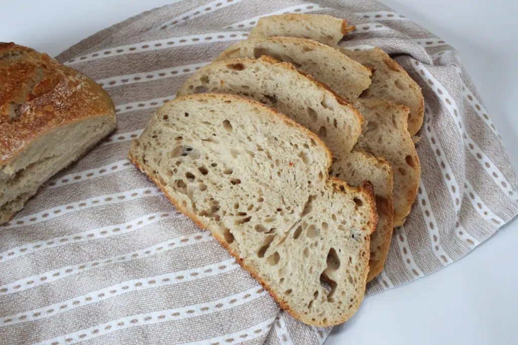 Sourdough bread sliced laying on a hand towel.